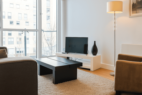 Bright living room with large windows and contemporary furniture in Tower Hill Deluxe One Bed.