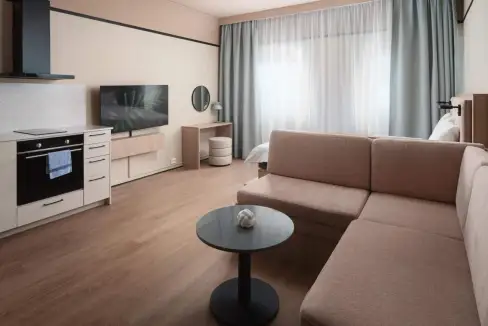 Comfortable apartment interior with sofa, TV, and large window in Stockholm Kungsholmen Aparthotel.