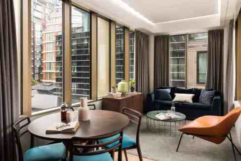 Bright living room with large windows, stylish furniture, and cityscape views at Bankside Bear Garde.