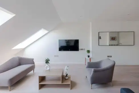 Bright living room in Soho Hollen Street Apartments with sleek furniture and large windows.
