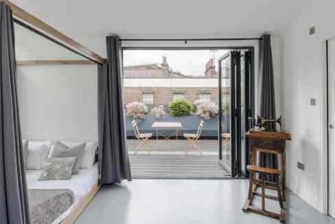 Bright apartment with balcony overlooking city rooftops.