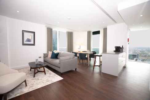Elegant living room with a cozy grey sofa and large windows in Canary Wharf serviced apartments.