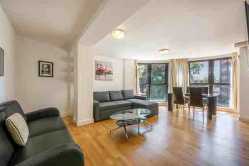 Spacious living room in Camden Crowndale Road Apartments featuring large windows, contemporary furni.