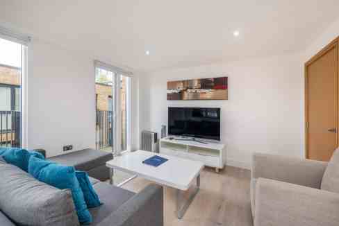 Living room at Euston Grafton Place Apartments with modern furniture and natural light.