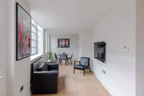 Modern apartment living room in Clerkenwell with stylish furniture and large windows.