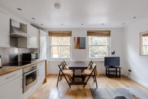 Bright, airy space with white cabinetry, wooden accents, and large windows.