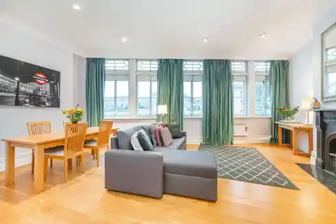 Spacious interior featuring a cozy gray sofa, wooden dining table, and stylish decor.