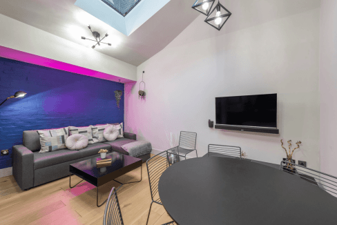 Stylish interior featuring a cozy sofa, vibrant lighting, and a sleek dining area.