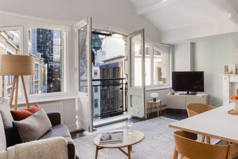 Bright living room with large windows and city views at Fenchurch Creechurch Lane Apartments.