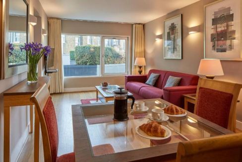 Modern living room with large windows and stylish decor at Borough Long Lane Apartments.