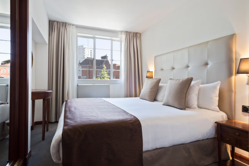 Bright and cozy Albany Street Aparthotel bedroom with large window and stylish decor.