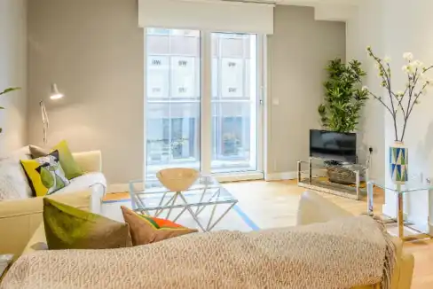 Bright living room with modern furniture and large windows in Victoria Howick Place Apartments.