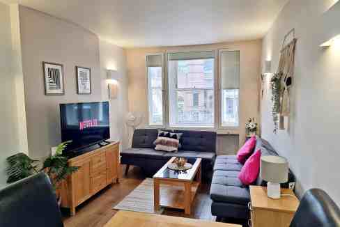 Living room with modern furniture and large windows in Liverpool Street Bishopsgate Apartments.