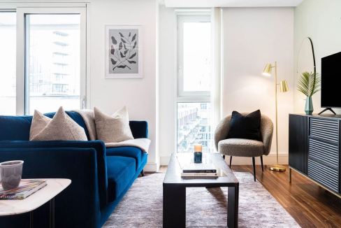 Bright, contemporary interior featuring a blue sofa, cozy armchair, and sleek decor.