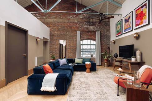 Industrial living room with brick walls, large window, and contemporary furniture at Dulcie Street W.