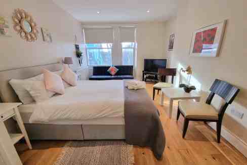 Cozy bedroom in Ladbroke Grove Oxford Gardens apartment with modern decor and natural light.