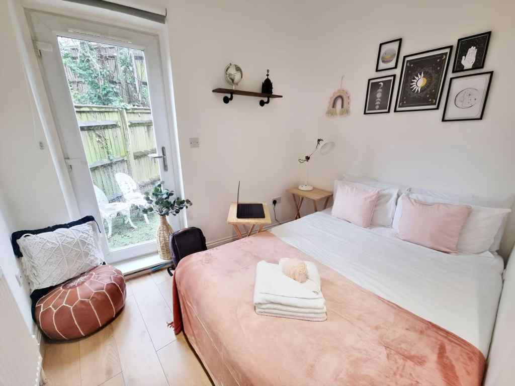 Modern bedroom with soft pink bedding and stylish decor in Lewisham Loampit Hill Apartments.