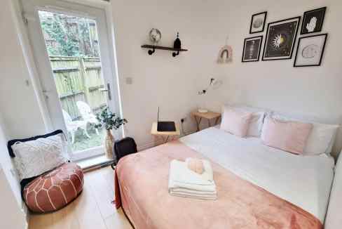 Modern bedroom with soft pink bedding and stylish decor in Lewisham Loampit Hill Apartments.