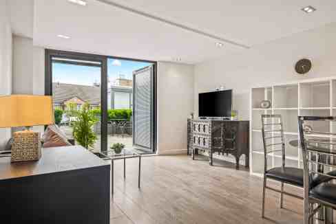 Bright and airy living space in Hoxton Mintern St Apartments with balcony and contemporary decor.