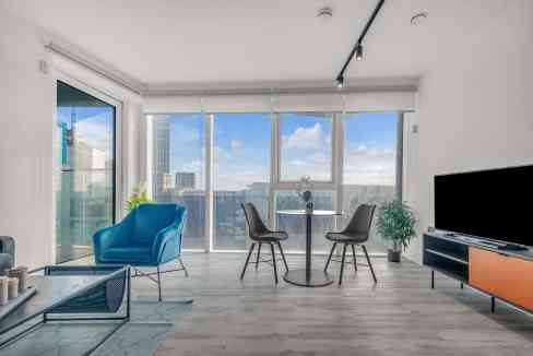 Modern living room with large windows and city views in North Acton serviced apartments.