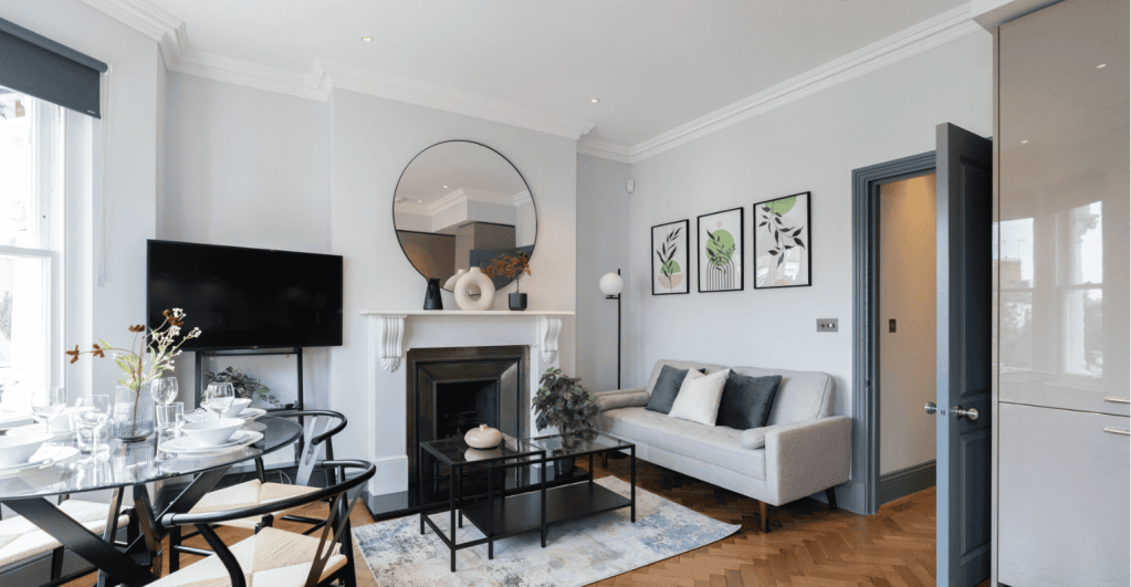 Stylish living room with sofa, fireplace, and wall art at Margravine Gardens Apartments.
