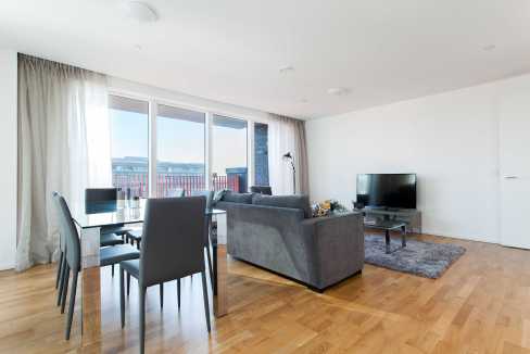Spacious living room in Canary Wharf Millharbour apartment with city skyline views.