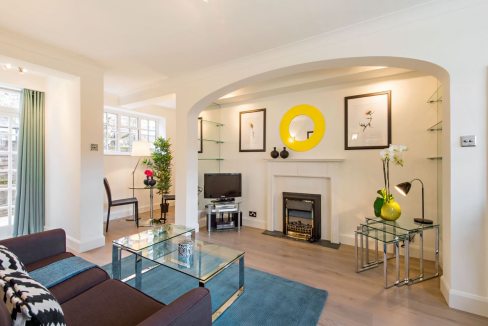 Bright and modern living room at Chelsea Rosemoor Street Apartments with stylish decor and cozy seat.