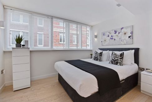 Bright bedroom with large windows and contemporary decor in Covent Garden West Street.