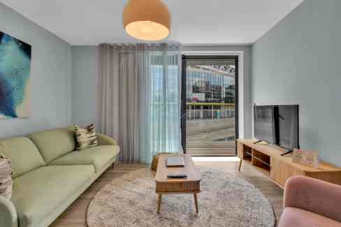 Wembley Stadium views from a stylish living room with contemporary furniture and natural light. Perf.