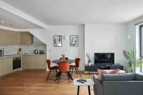 Spacious living room in Hammersmith Mews Apartments featuring contemporary furniture and natural lig.