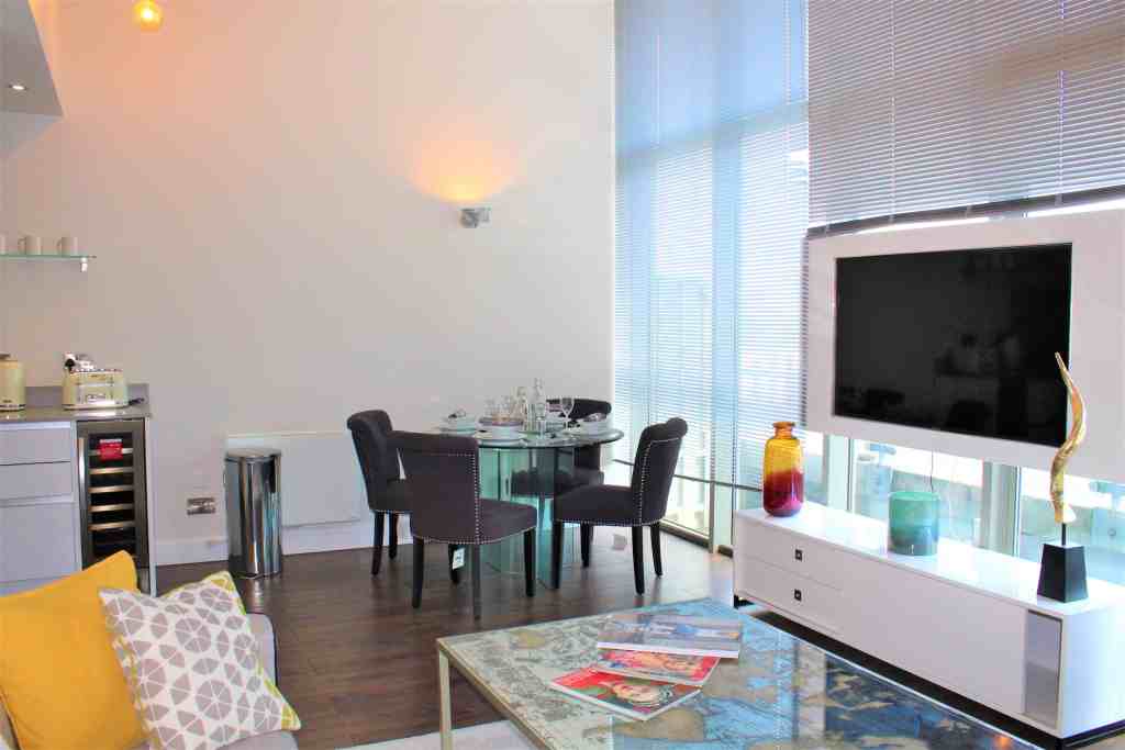 Contemporary penthouse apartment living room with large windows and stylish decor.