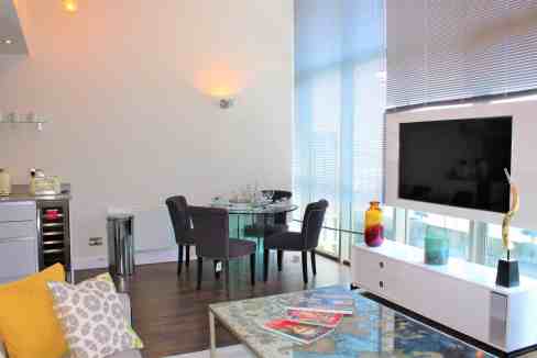 Contemporary penthouse apartment living room with large windows and stylish decor.