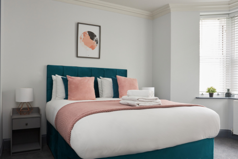 Bright bedroom with stylish decor and large window at Earl's Court Ongar Road Apartments.