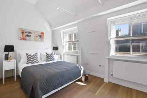 Bright, modern bedroom in Soho Berwick Street Apartments with large windows and minimalist decor.