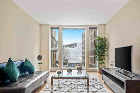 Bright living room with large windows, contemporary furniture, and a view of the cityscape.