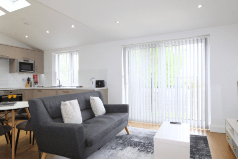 Bright living room with large windows and minimalist decor in West Finchley Nether Street Apartments.