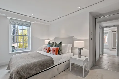 Bright, airy interior with white walls, stylish bedding, and contemporary lamps.