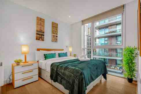 Bright bedroom with large windows, modern furnishings, and stylish decor in Aldgate East.