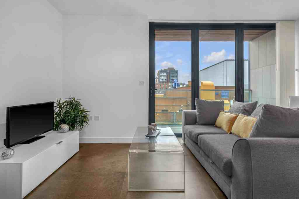 Contemporary living room with large balcony and city skyline view.