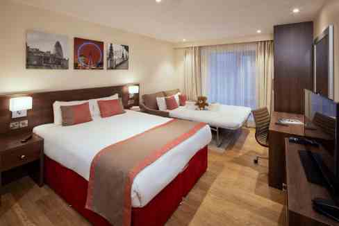 Comfortable hotel room with two beds and modern amenities.
