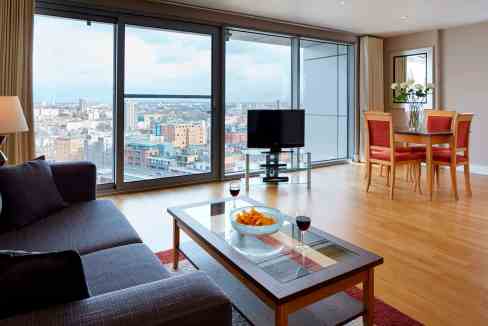 Bright living room with large windows overlooking London skyline.
