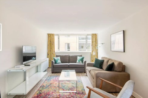 Bright and spacious living room with large windows and contemporary furniture in Holborn Lamb's Cond.