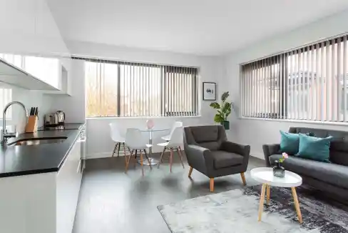 Modern living room in St Albans Abbey Apartments with stylish furniture and large windows.