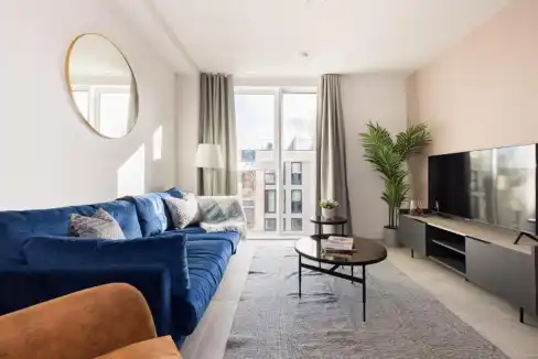 Modern Leeds Playhouse Apartments living room with large window and stylish decor.
