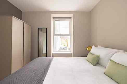 Plymouth Mutley Apartments bedroom featuring minimalist design, neutral tones, and natural daylight.