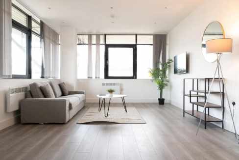 Bright, spacious living room in Brentford serviced apartments with large windows and contemporary de.