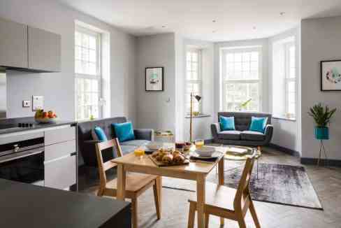 Bright living room with bay windows, contemporary decor, and cozy seating.