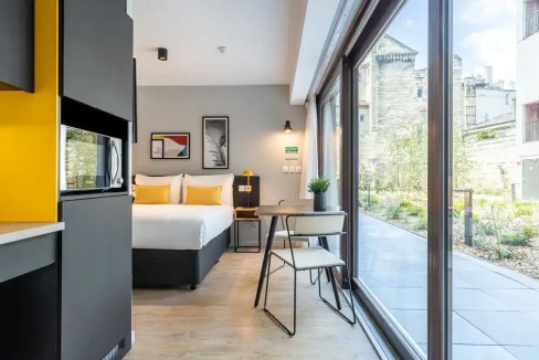 Contemporary hotel room with large windows and stylish decor at Rue Leyteire Aparthotel.