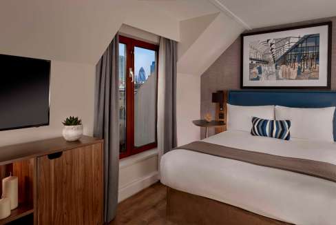 Comfortable bedroom at Barbican Goswell Road Aparthotel featuring contemporary design and scenic cit.