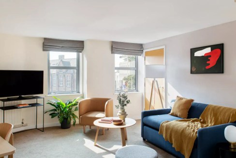 Bright living room in Nottingham's Ropewalk Apartments featuring contemporary furniture and large wi.